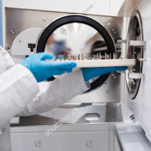 stock-photo-close-up-view-of-the-hands-of-female-dentistry-worker-who-puts-a-dental-instrument-into-autoclave-2121330317